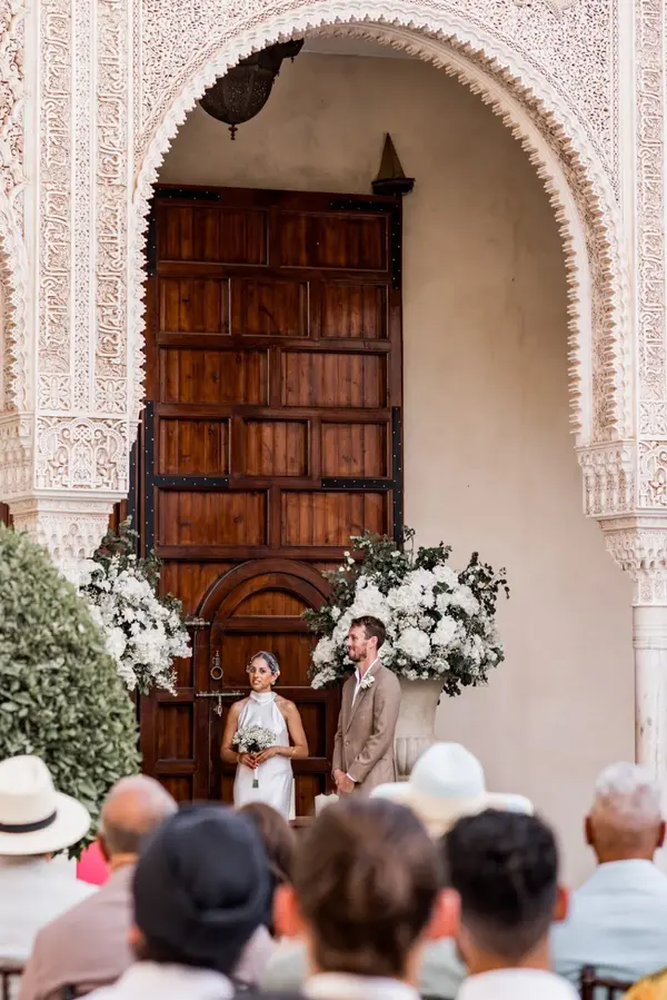 Wedding ceremony at Moroccan riad arch with floral arrangements - photography in marrakech
