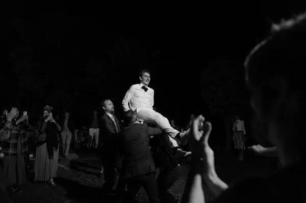 Groom lifted by guests celebration black and white - moroccan wedding photographer