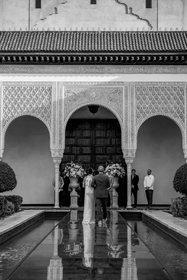 Couple at Moroccan palace courtyard water reflection black and white - photography marrakech