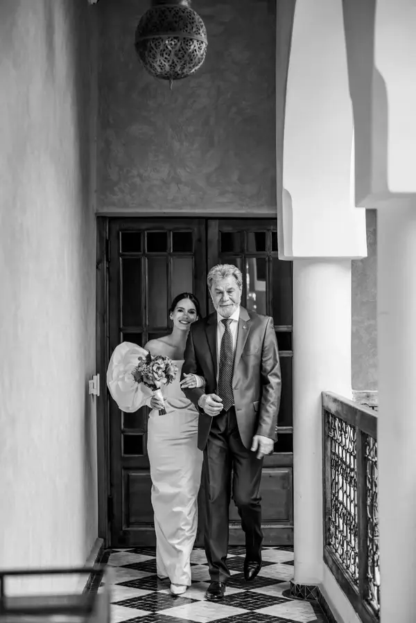 Bride walking with father Moroccan doorway black and white - photographer wedding