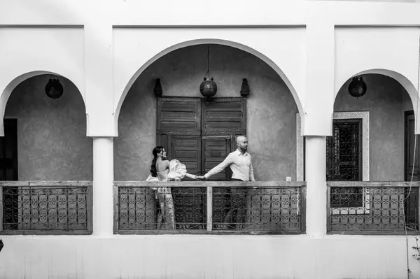 Couple on balcony traditional Moroccan riad arches black and white - photoshoot marrakech