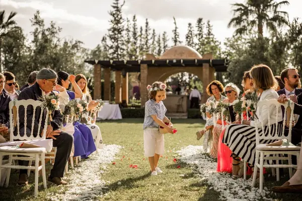 Flower girl scattering petals at garden wedding ceremony - wedding photographer
